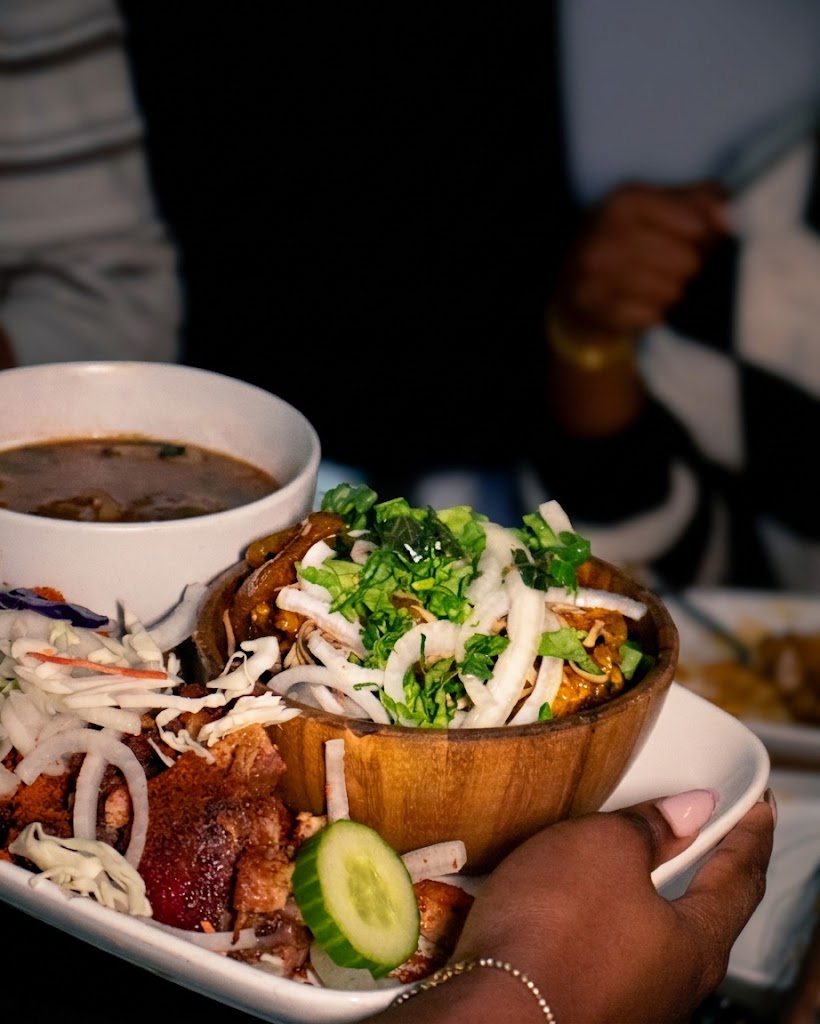 A bowl of peppered meat topped with onion and greens