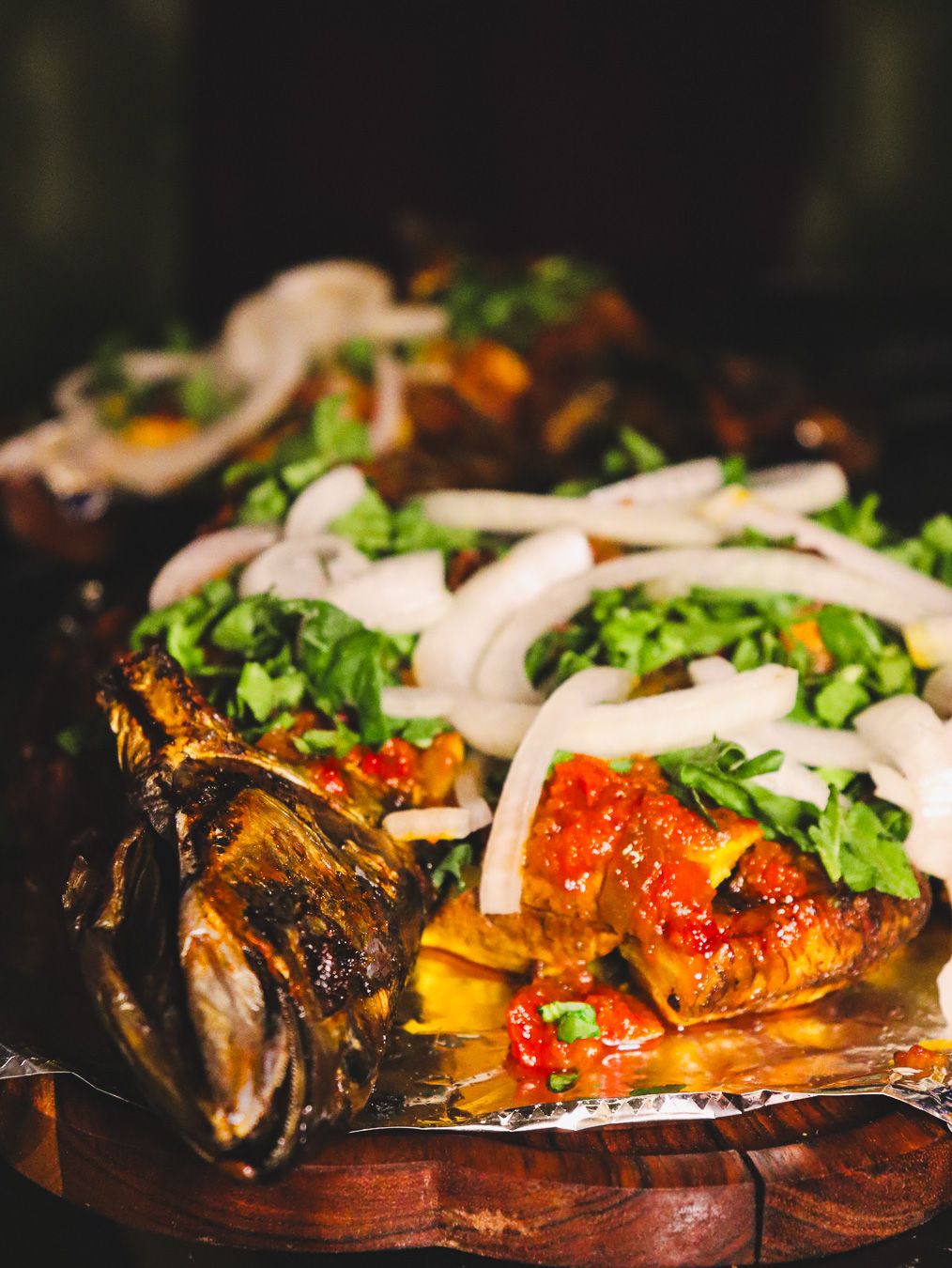 Grilled fish under peppers and onions